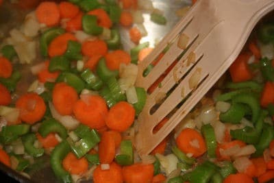 spatula stirring carrots, onion, celery