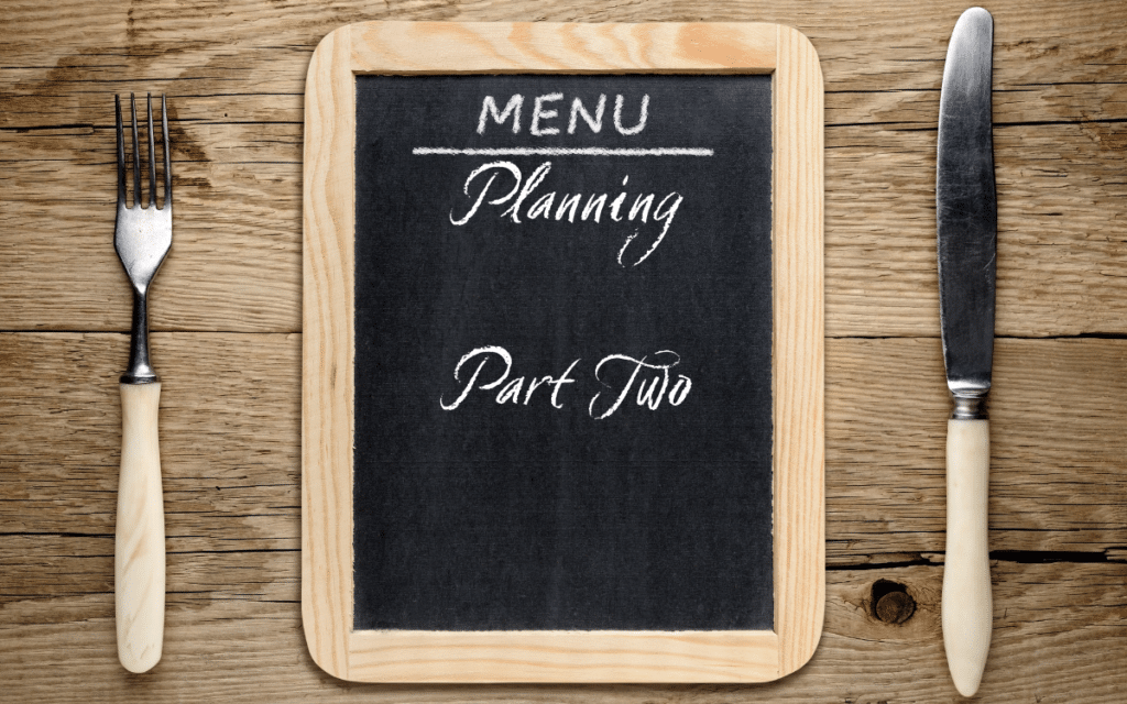 menu planning part two - chalkboard on table with fork and knife that says menu planning part two