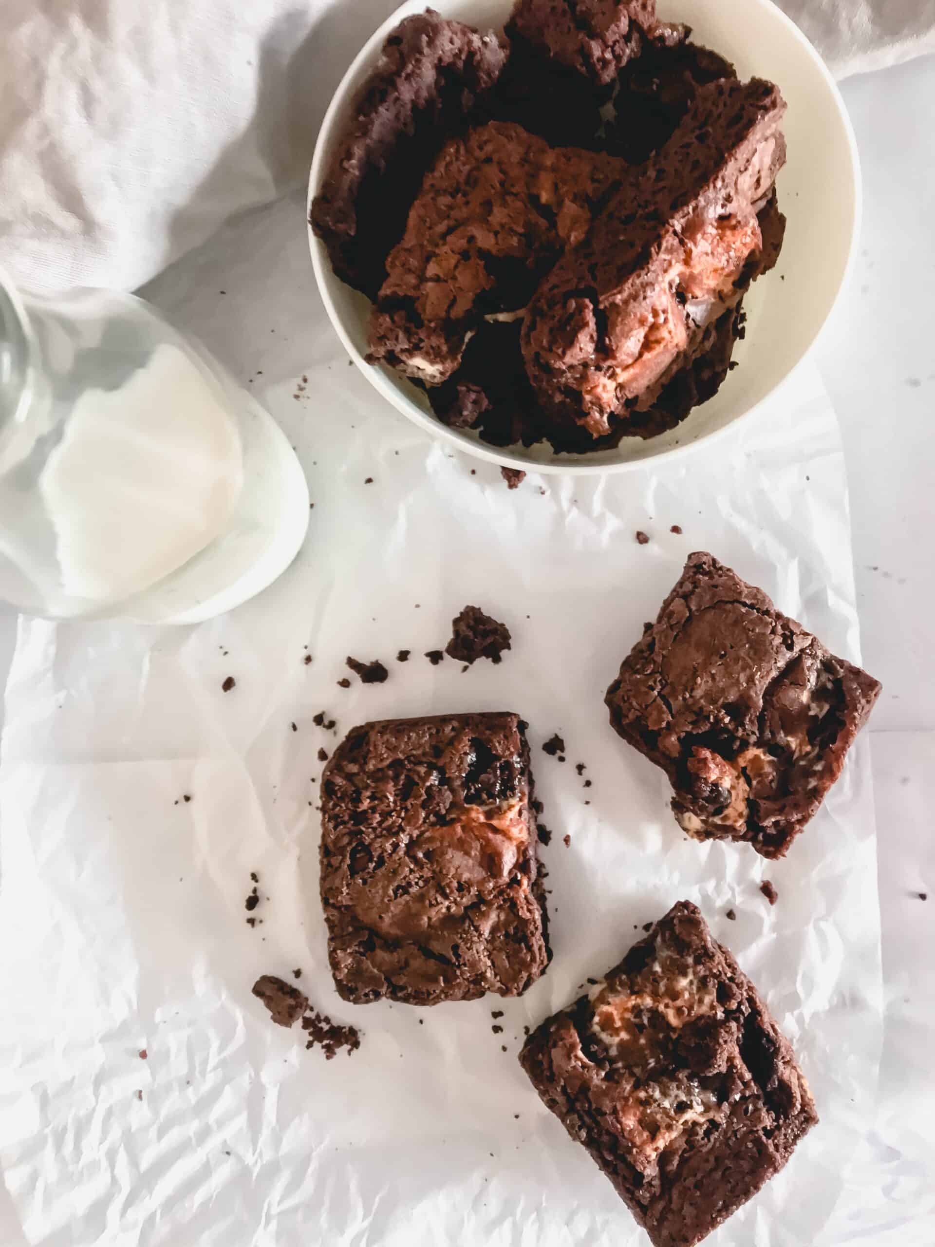 brownies and milk sitting on white cloth