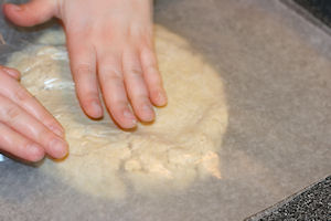 Dough between sheets of PARCHMENT paper.