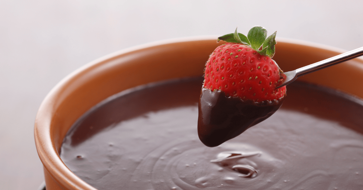 strawberry being dipped into chocolate fondue