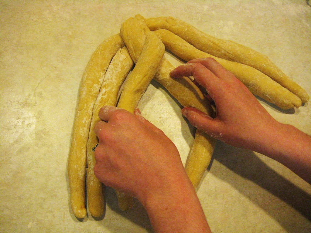 Six strands of challah dough being braided